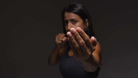 Studio-Portrait-Of-Mature-Woman-Wearing-Gym-Fitness-Clothing-Exercising-Sparring-At-Camera-2